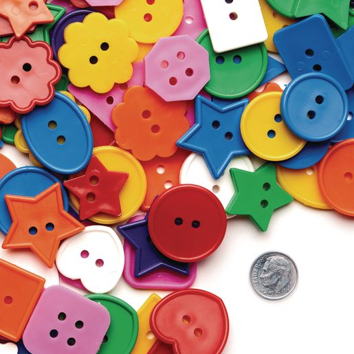 A colorful assortment of buttons in various shapes like stars, flowers, and hearts, scattered beside a dime on a white background. Joyful and playful.